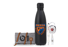 A black water bottle with an OKEDA logo, a gray felt pouch with a b logo, a white pen, and a white retractable badge holder with a red logo showcase premium branded products.