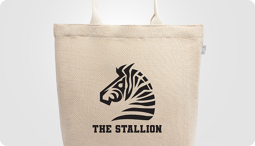 A beige tote bag featuring a black graphic of a stylized zebra head and the words THE STALLION printed below the image—perfect as custom merchandise for stylish branded products.