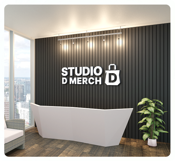 A modern office reception area with a white desk, a potted plant, floor-to-ceiling windows overlooking the city, and a black wall featuring the “STUDIO D MERCH” logo with a shopping bag icon showcasing custom merchandise.